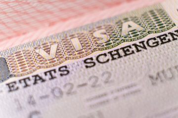 Macro shot biometric passport with schengen visa. European visitor visa for tourism and travel in EU.