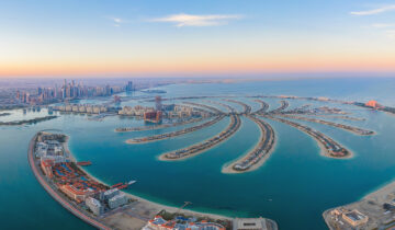 Aerial view of The Palm Jumeirah Island, Dubai Downtown skyline, United Arab Emirates or UAE. Financial district and business area in smart urban city. Skyscraper and high-rise buildings at sunset.
