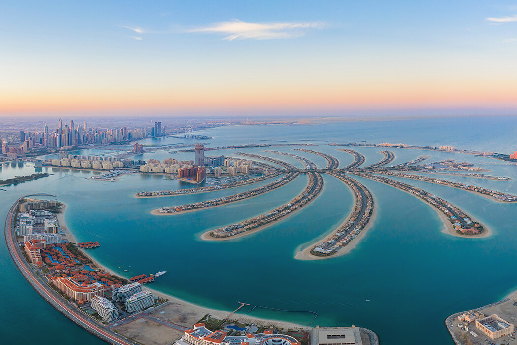 Aerial view of The Palm Jumeirah Island, Dubai Downtown skyline, United Arab Emirates or UAE. Financial district and business area in smart urban city. Skyscraper and high-rise buildings at sunset.