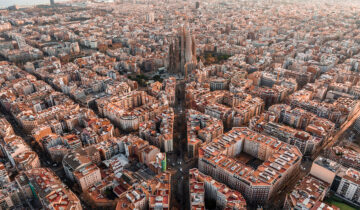 Aerial view of Barcelona City Skyline and Sagrada Familia Cathedral at sunset. Eixample residential famous urban grid. Cityscape with typical urban octagon blocks