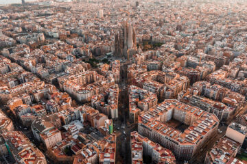 Aerial view of Barcelona City Skyline and Sagrada Familia Cathedral at sunset. Eixample residential famous urban grid. Cityscape with typical urban octagon blocks